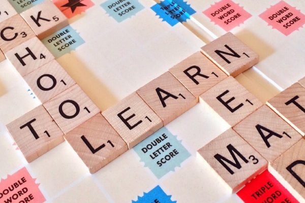 Close-up of Scrabble tiles forming words related to education and school.